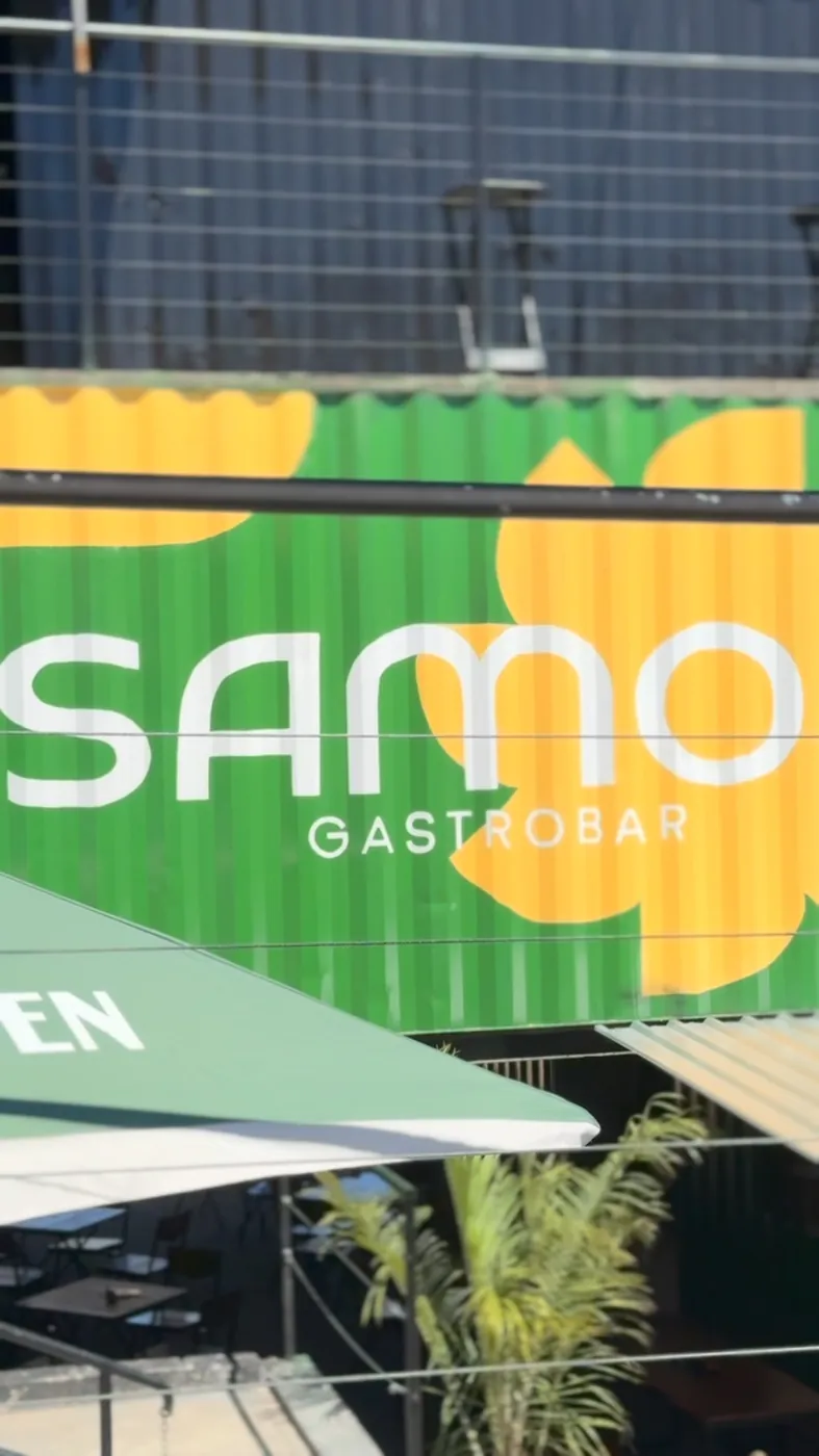 Container verde com a flor amarela e o logo Samoa Gastrobar