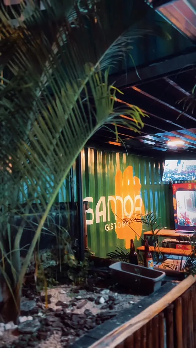 Container com o logo Samoa iluminado à noite