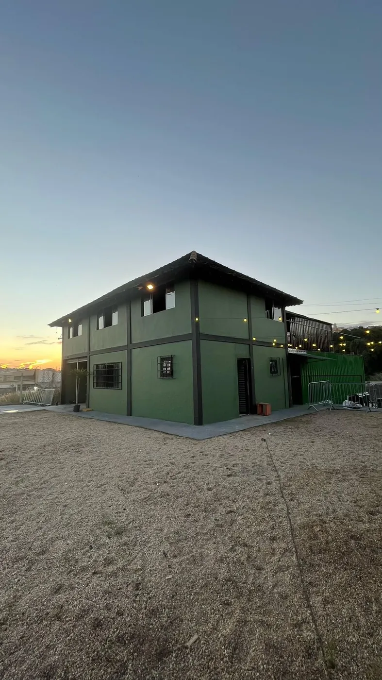 Casa verde de dois andares ao pôr do sol