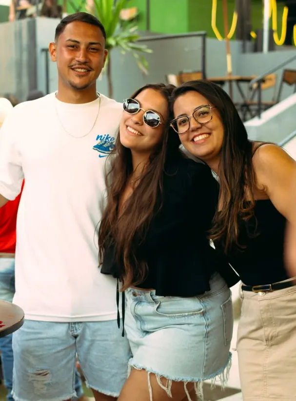 Trio de amigos sorrindo na área externa